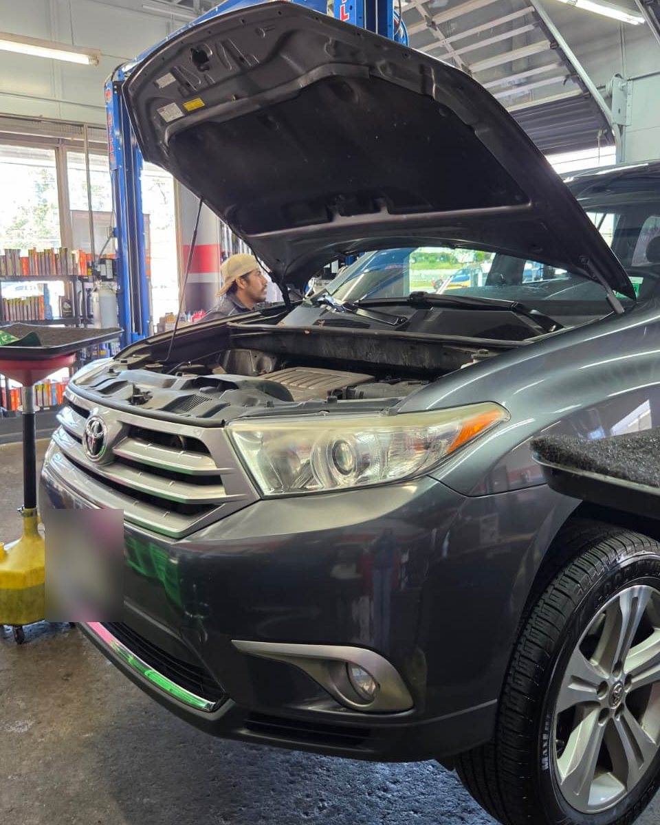 A Frontline technician working on an SUV raised on the lift in the Annandale bays