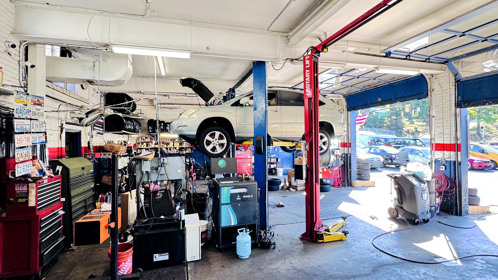 The service bays at Frontline Auto Plus in Arlington, with a vehicle raised on the lift and the bay door open to Columbia Pike